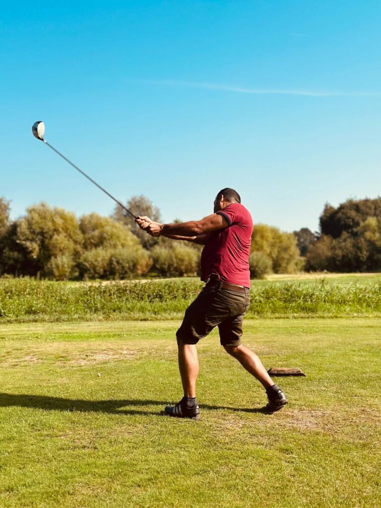 magnetic cigar clip golf - man swinging golf club on lush green course action shot